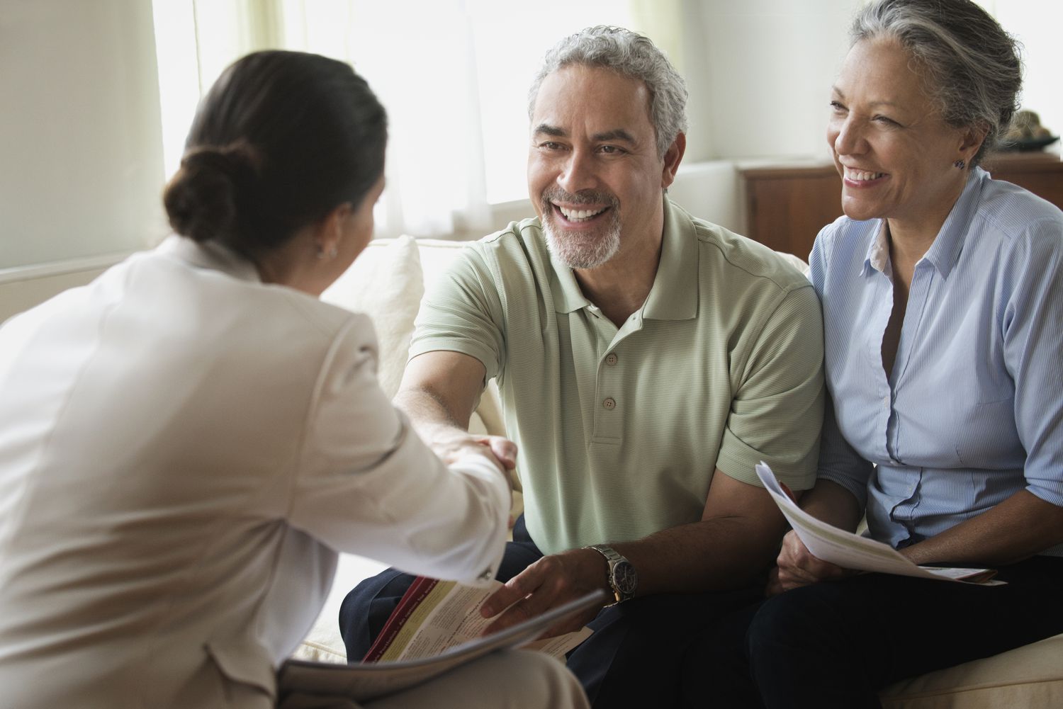 hispanic-saleswoman-talking-to-clients-in-living-room-580504711-5995f8d722fa3a001149763c